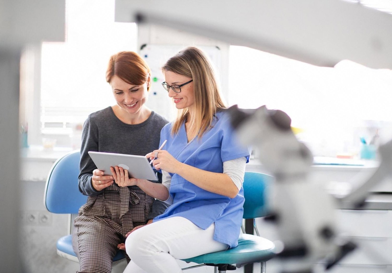 Orthodontist reviewing a personalised braces treatment plan on a tablet with a patient in a UAE dental clinic